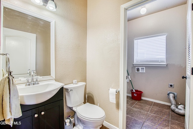 11352 Bullseye St, El Paso, TX 79934 - half bath with toilet, vanity, tile patterned floors, and baseboards