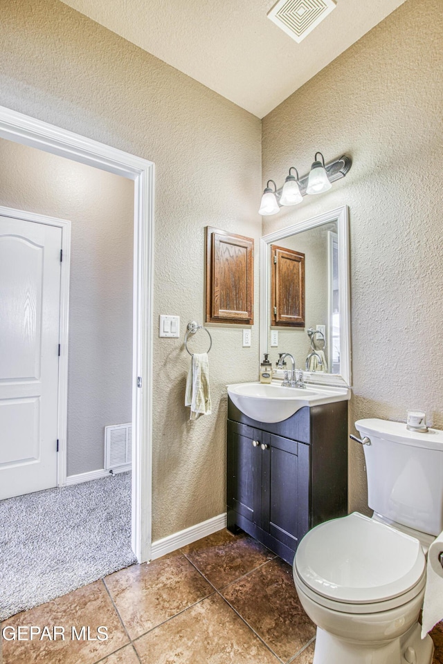 11352 Bullseye St, El Paso, TX 79934 - bathroom featuring vanity, a textured wall, tile patterned floors, toilet, and baseboards