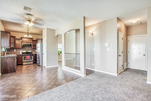 11352 Bullseye St, El Paso, TX 79934 - kitchen with appliances with stainless steel finishes, range hood, a ceiling fan, arched walkways, and a textured ceiling