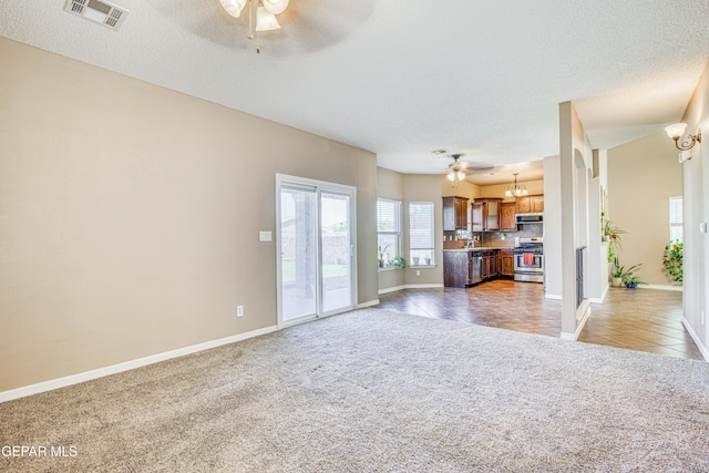 11352 Bullseye St, El Paso, TX 79934 - unfurnished living room featuring ceiling fan, light colored carpet, baseboards, light tile patterned floors, and a textured ceiling