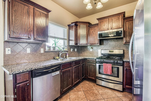 11352 Bullseye St, El Paso, TX 79934 - kitchen with stainless steel appliances, a sink, light tile patterned floors, a chandelier, and tasteful backsplash