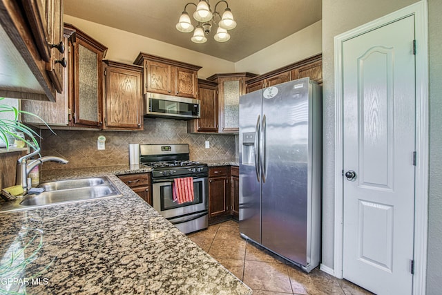 11352 Bullseye St, El Paso, TX 79934 - kitchen with stainless steel appliances, a sink, a chandelier, decorative backsplash, and light tile patterned floors