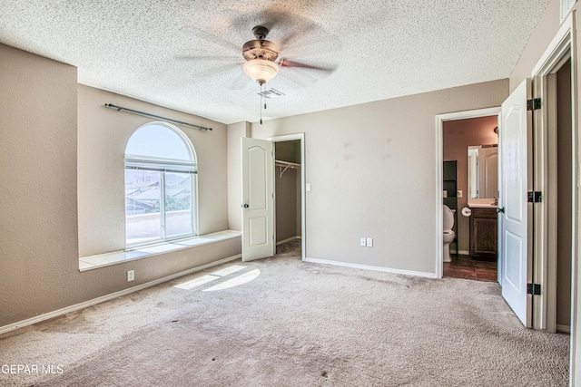 11352 Bullseye St, El Paso, TX 79934 - unfurnished bedroom with carpet flooring, a spacious closet, a textured ceiling, a closet, and baseboards