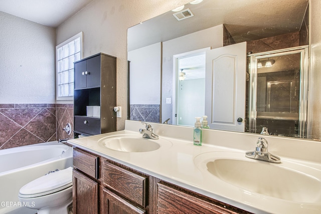 11352 Bullseye St, El Paso, TX 79934 - bathroom with double vanity, a stall shower, toilet, a garden tub, and a textured wall