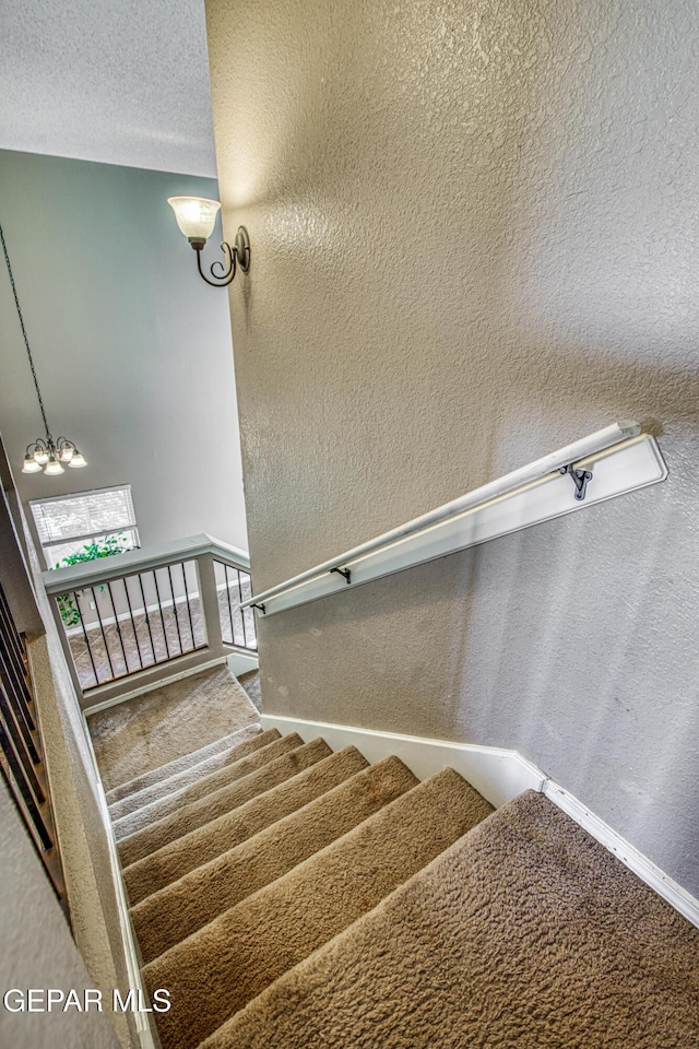 11352 Bullseye St, El Paso, TX 79934 - stairs with a chandelier, a textured wall, and carpet