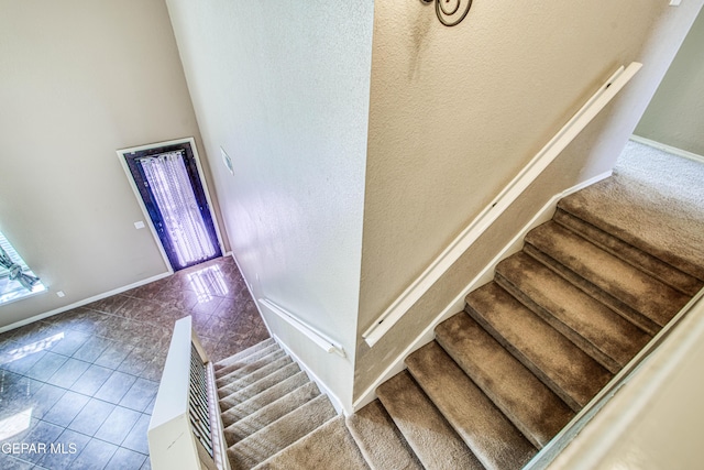 11352 Bullseye St, El Paso, TX 79934 - stairs featuring baseboards, a high ceiling, tile patterned floors, and a textured wall