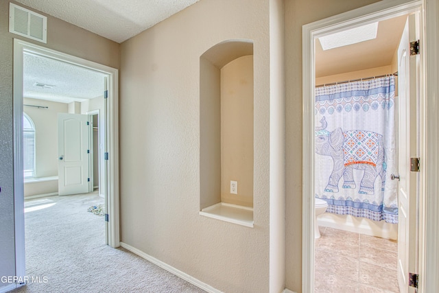 11352 Bullseye St, El Paso, TX 79934 - hallway featuring a textured ceiling, arched walkways, and baseboards