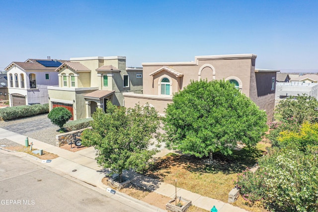 11352 Bullseye St, El Paso, TX 79934 - view of front of house featuring stucco siding, a residential view, driveway, and an attached garage