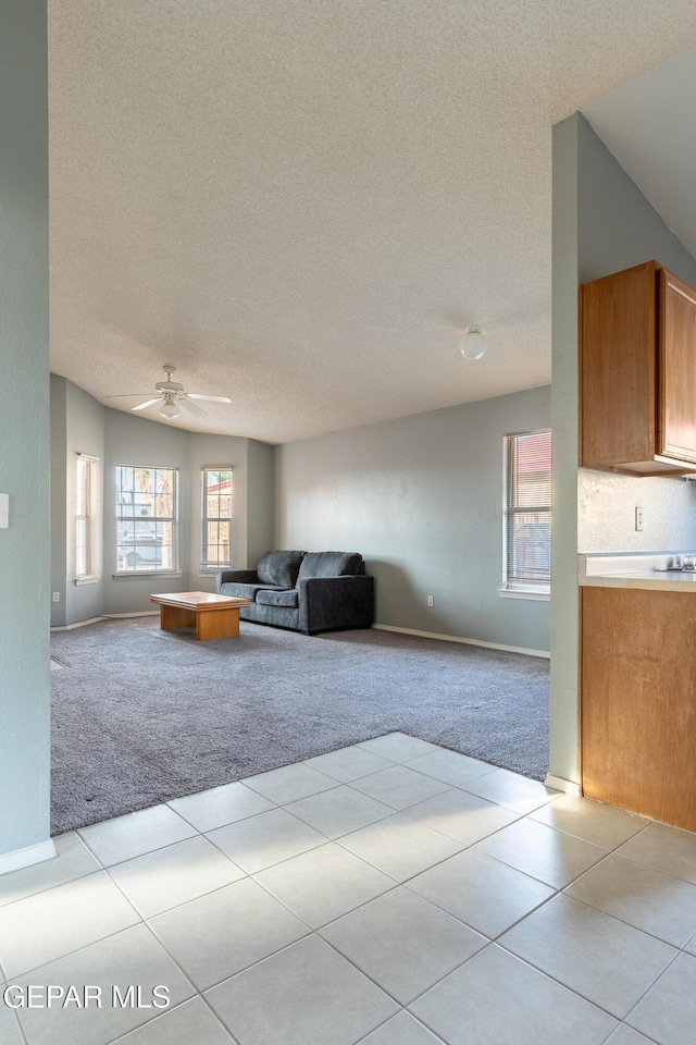 6224 Rhine Bridge Dr, El Paso, TX 79934 - living area with light colored carpet, a textured ceiling, a ceiling fan, and light tile patterned floors