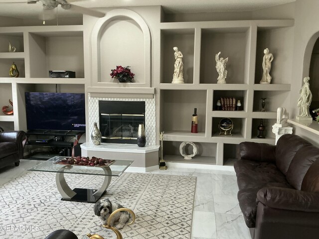 729 Cinnamon Teal Cir, El Paso, TX 79932 - living room featuring marble finish floors, built in shelves, ceiling fan, a glass covered fireplace, and arched walkways