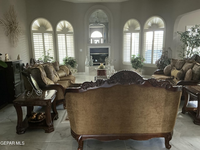 729 Cinnamon Teal Cir, El Paso, TX 79932 - living area featuring a glass covered fireplace, marble look tile flooring, and ceiling fan