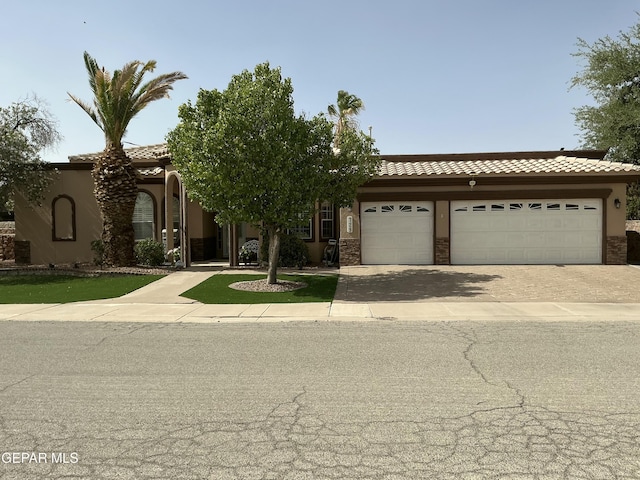729 Cinnamon Teal Cir, El Paso, TX 79932 - view of front of home with stucco siding, a tiled roof, an attached garage, and driveway