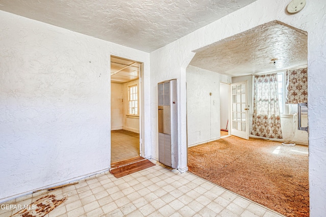 124 N Toledo Pl, El Paso, TX 79905 - unfurnished room with a heating unit, a textured wall, tile patterned floors, a textured ceiling, and baseboards