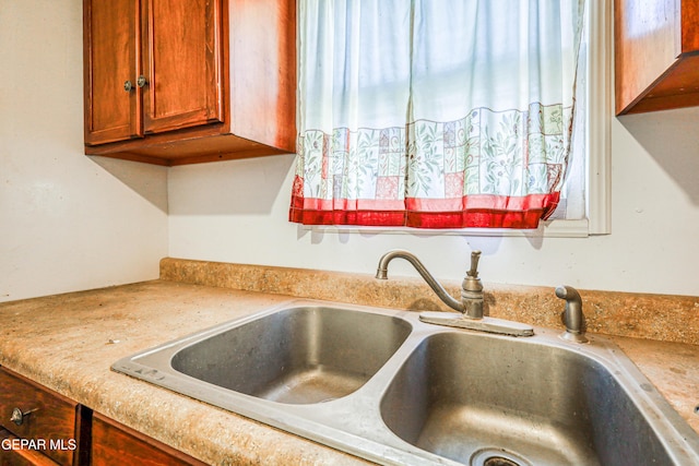 124 N Toledo Pl, El Paso, TX 79905 - kitchen view of a sink, light countertops, and brown cabinetry