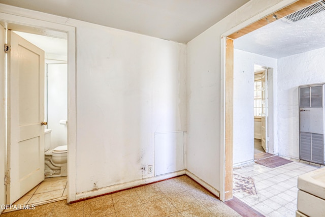 124 N Toledo Pl, El Paso, TX 79905 - unfurnished bedroom with a heating unit, ensuite bath, and light floors