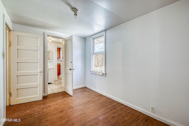 124 N Toledo Pl, El Paso, TX 79905 - unfurnished bedroom with hardwood / wood-style flooring, baseboards, and ensuite bathroom