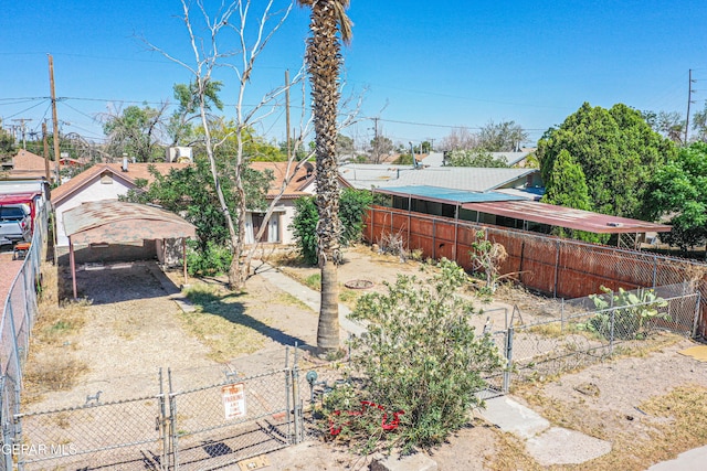 124 N Toledo Pl, El Paso, TX 79905 - fenced yard featuring a detached carport, a gate, and driveway