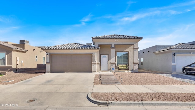 13936 Garforth Ave, El Paso, TX 79928 - view of front facade featuring a tile roof, stucco siding, a garage, and driveway