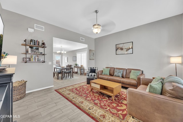 13936 Garforth Ave, El Paso, TX 79928 - living room with light wood finished floors, a chandelier, a ceiling fan, and baseboards