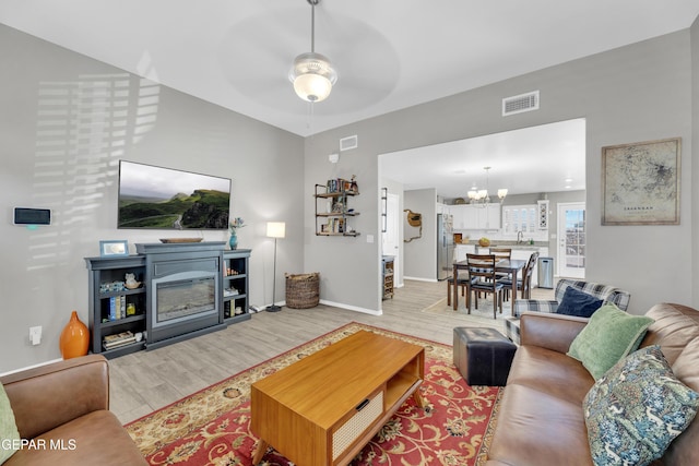 13936 Garforth Ave, El Paso, TX 79928 - living room with a chandelier, a ceiling fan, baseboards, and light wood finished floors