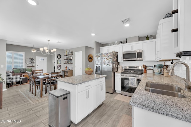 13936 Garforth Ave, El Paso, TX 79928 - kitchen featuring appliances with stainless steel finishes, a sink, decorative backsplash, a chandelier, and white cabinetry