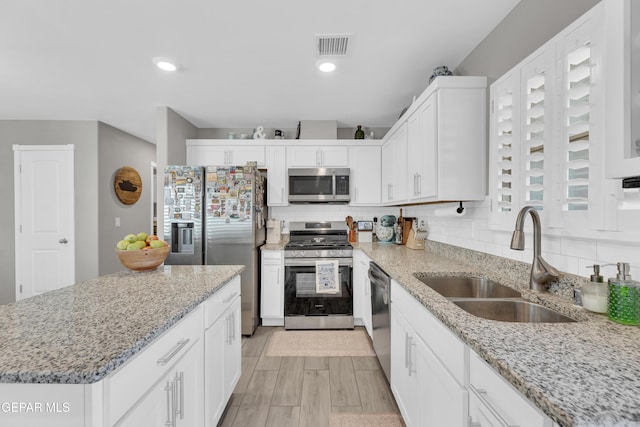 13936 Garforth Ave, El Paso, TX 79928 - kitchen featuring stainless steel appliances, a sink, white cabinetry, backsplash, and recessed lighting