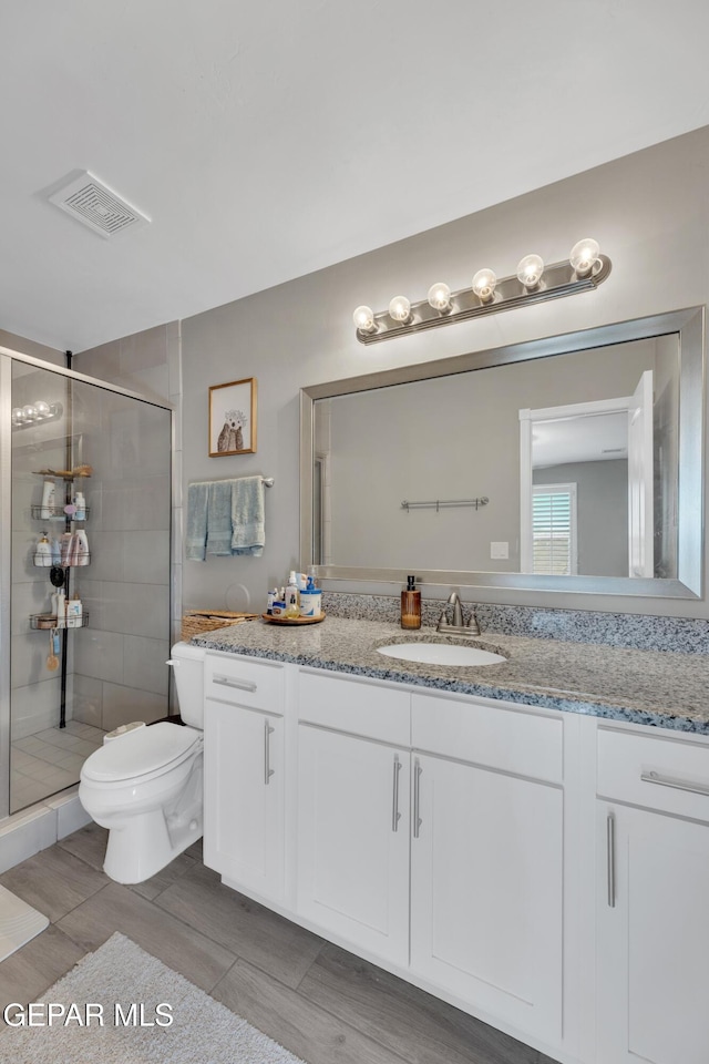 13936 Garforth Ave, El Paso, TX 79928 - full bath with toilet, vanity, a shower stall, and wood finished floors