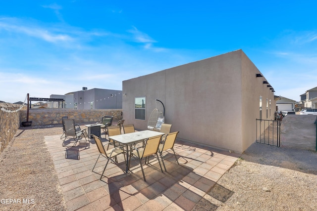 13936 Garforth Ave, El Paso, TX 79928 - fenced backyard featuring an outdoor fire pit, a patio area, outdoor dining space, and a gate