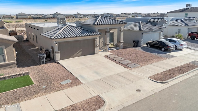 13936 Garforth Ave, El Paso, TX 79928 - mediterranean / spanish-style house featuring an attached garage, concrete driveway, stucco siding, and a residential view