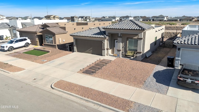13936 Garforth Ave, El Paso, TX 79928 - view of front of property featuring a residential view, stucco siding, a tiled roof, an attached garage, and concrete driveway