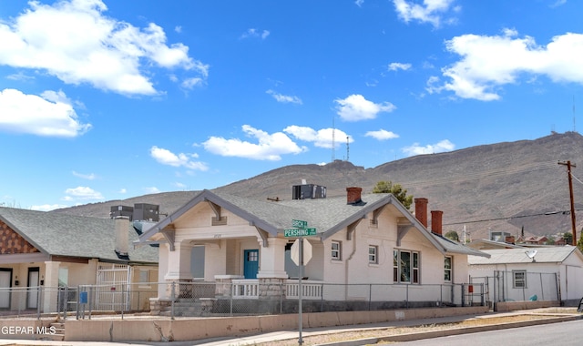 2729 Pershing Dr, El Paso, TX 79903 - view of front facade with a chimney, a mountain view, covered porch, and a fenced front yard