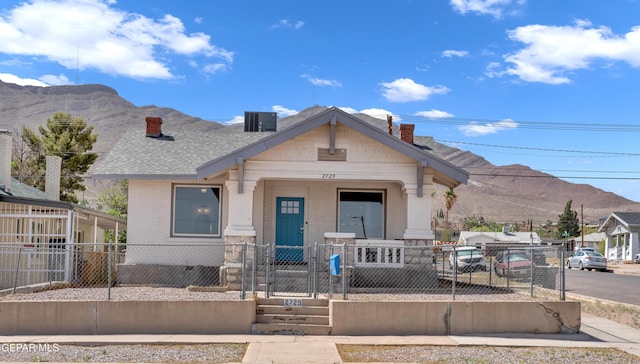2729 Pershing Dr, El Paso, TX 79903 - view of front of house with a chimney, brick siding, a mountain view, a fenced front yard, and a gate