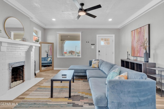2729 Pershing Dr, El Paso, TX 79903 - living room featuring ornamental molding, a textured ceiling, ceiling fan, plenty of natural light, and a brick fireplace