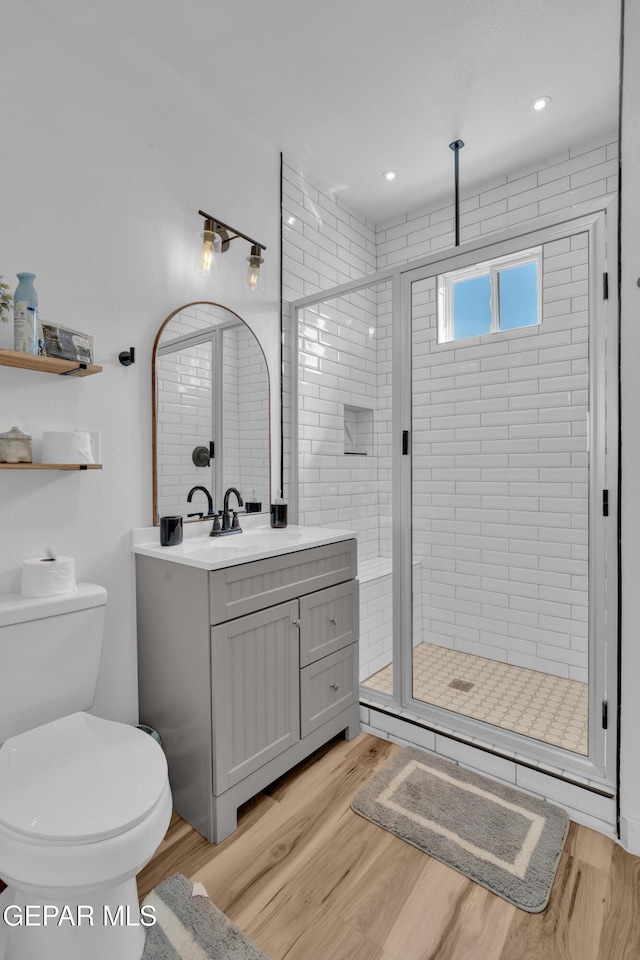 2729 Pershing Dr, El Paso, TX 79903 - full bath with wood finished floors, vanity, a shower stall, and toilet