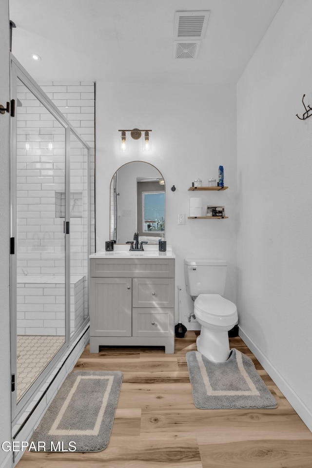 2729 Pershing Dr, El Paso, TX 79903 - full bathroom with vanity, toilet, wood finished floors, and a shower stall