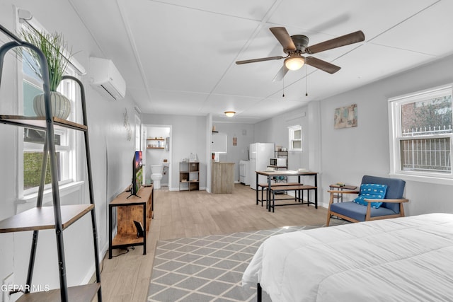 2729 Pershing Dr, El Paso, TX 79903 - bedroom featuring freestanding refrigerator, light wood finished floors, a wall unit AC, and multiple windows