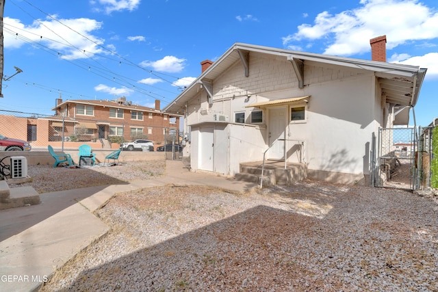2729 Pershing Dr, El Paso, TX 79903 - back of house featuring a chimney, a gate, and stucco siding
