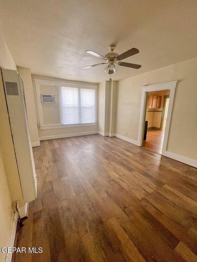 2526 Yandell Dr, El Paso, TX 79903 - empty room featuring wood finished floors, a heating unit, a ceiling fan, an AC wall unit, and a textured ceiling