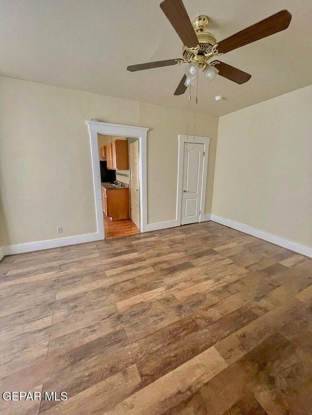 2526 Yandell Dr, El Paso, TX 79903 - unfurnished bedroom with wood finished floors, baseboards, and a ceiling fan