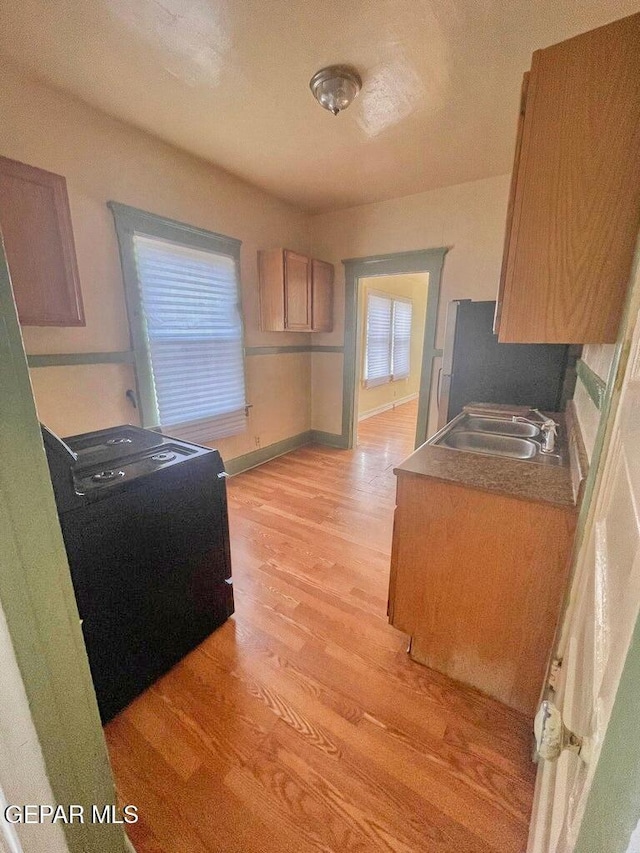 2526 Yandell Dr, El Paso, TX 79903 - kitchen with a sink, light wood-style flooring, freestanding refrigerator, and baseboards