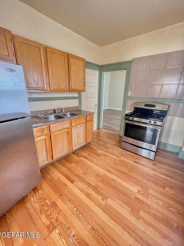 2526 Yandell Dr, El Paso, TX 79903 - kitchen featuring stainless steel appliances, a sink, light wood-style flooring, and dark countertops