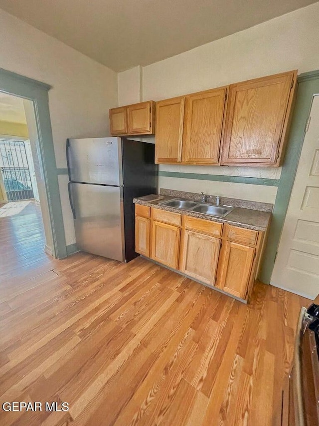 2526 Yandell Dr, El Paso, TX 79903 - kitchen featuring freestanding refrigerator, a sink, and light wood-style flooring