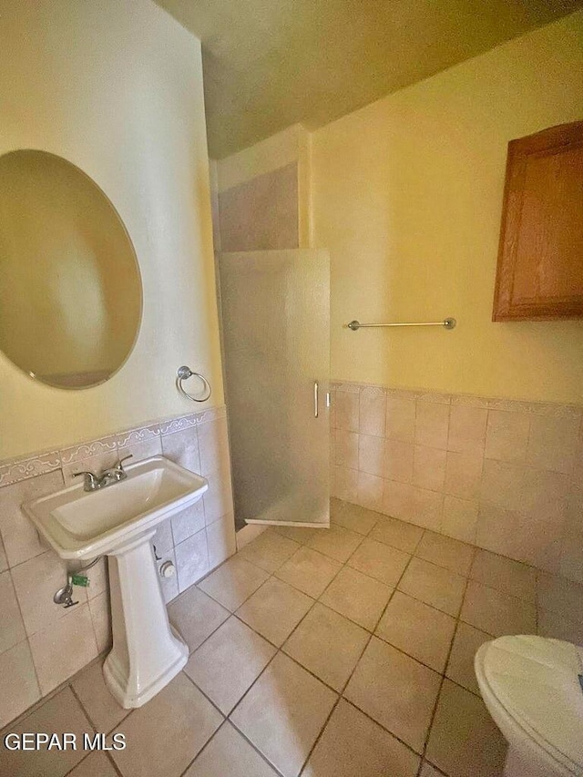 2526 Yandell Dr, El Paso, TX 79903 - full bath featuring tile walls, a shower stall, toilet, tile patterned floors, and wainscoting