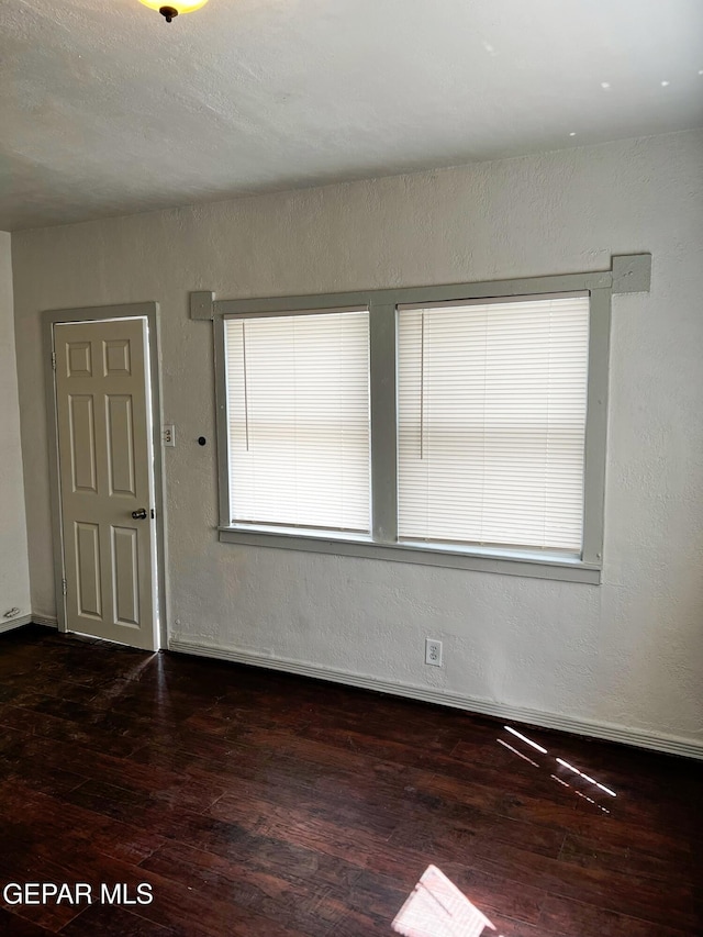 2526 Yandell Dr, El Paso, TX 79903 - spare room with dark wood-style flooring, baseboards, and a textured wall