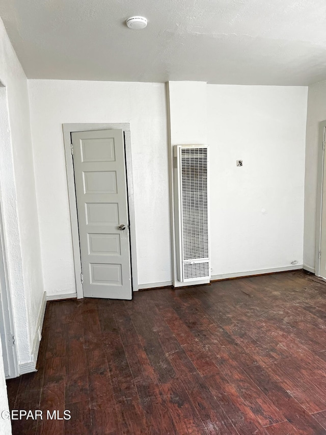 2526 Yandell Dr, El Paso, TX 79903 - spare room featuring a heating unit, wood-type flooring, baseboards, and a smoke detector
