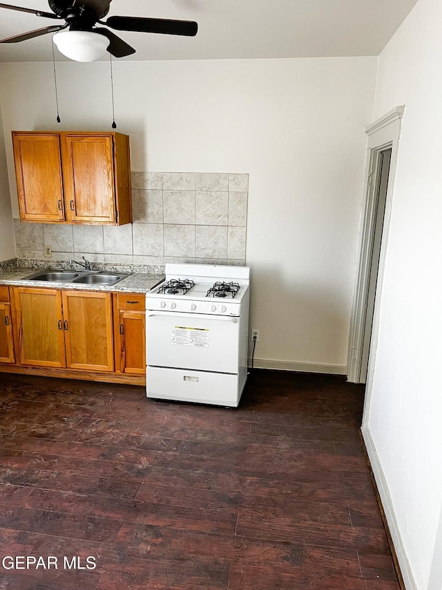 2526 Yandell Dr, El Paso, TX 79903 - kitchen with gas range gas stove, a sink, brown cabinetry, ceiling fan, and dark wood-style floors