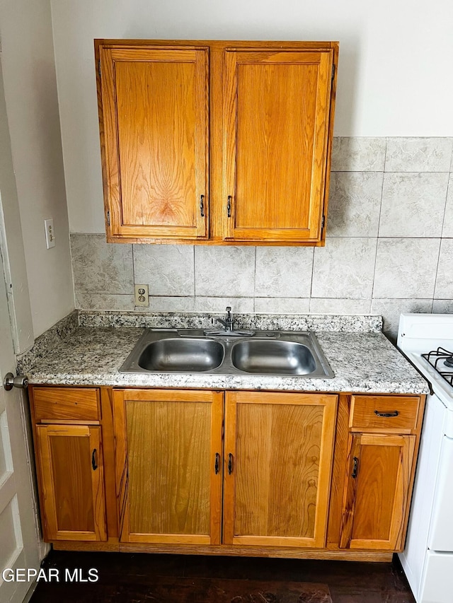 2526 Yandell Dr, El Paso, TX 79903 - kitchen with white range with gas cooktop, a sink, and brown cabinetry
