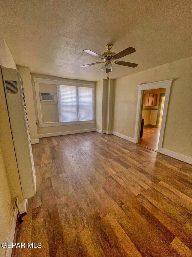 2526 Yandell Dr, El Paso, TX 79903 - spare room with hardwood / wood-style floors, a textured ceiling, a heating unit, a ceiling fan, and an AC wall unit