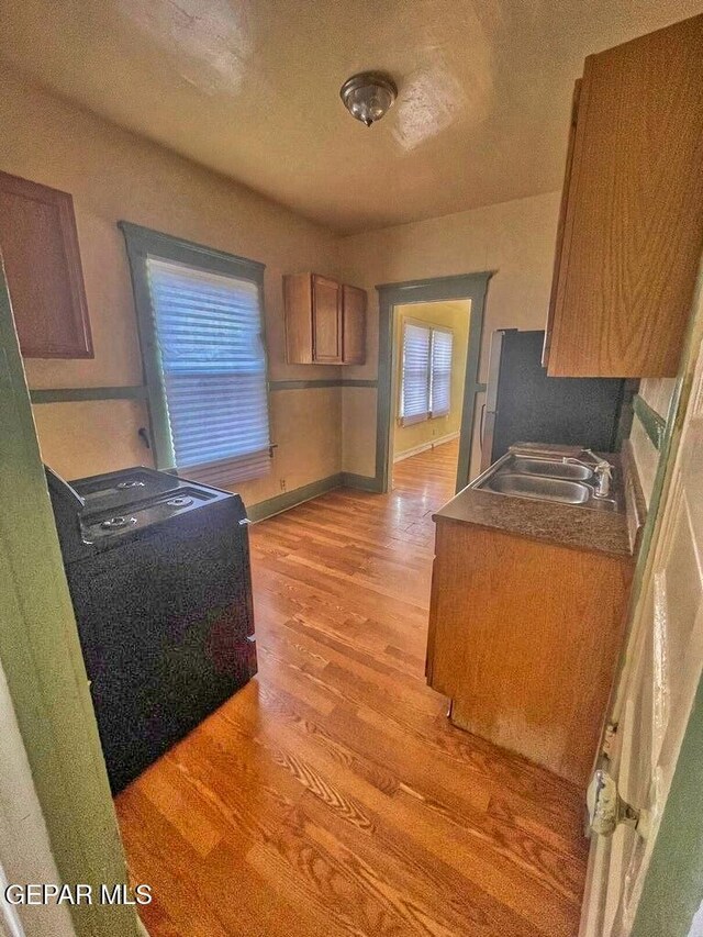 2526 Yandell Dr, El Paso, TX 79903 - kitchen featuring a sink, light wood-type flooring, freestanding refrigerator, and baseboards