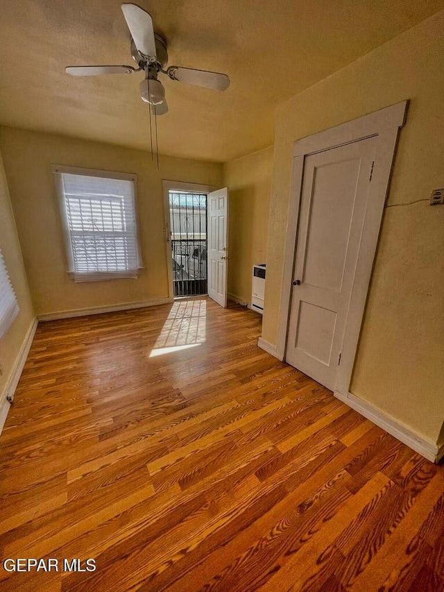 2526 Yandell Dr, El Paso, TX 79903 - empty room featuring wood finished floors, baseboards, a ceiling fan, and heating unit